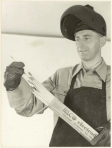 Een medewerker bij draadindustrie Hilarius BV. toont vervaardigde elektroden. NL-HlmNHA 54004080