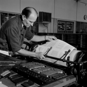 Een medewerker controleert het drukwerk op de drukpers, Bestanddeelnr 254-5250