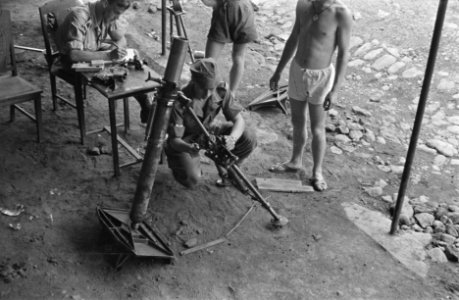 Een militair ( schouderepauletten onbekend) noteert iets in een schrift terwijl, Bestanddeelnr 458-2-4