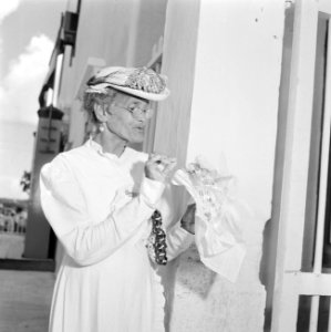 Een oude vrouw met bloemen bij de koninklijke ontvangst op Bonaire, Bestanddeelnr 252-3844