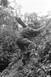 Een Nederlands militair klimt met een .50 machinegeweer op zijn rug, Bestanddeelnr 465-5-3