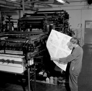 Een medewerker in de drukkerij bezig met het controleren van proefdrukken, Bestanddeelnr 254-5213