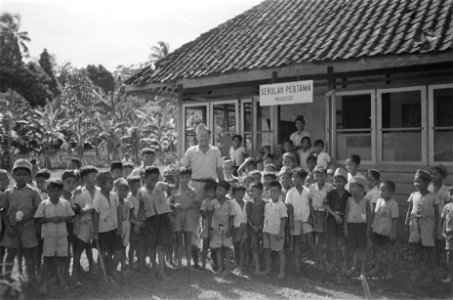 Een Nederlandse man (onderwijzer) poseert met een groep schoolkinderen (jongens, Bestanddeelnr 428-2-4