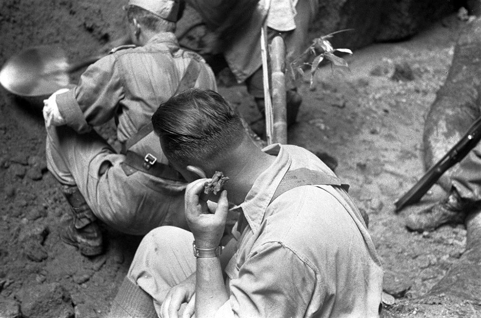 Een Nederlandse militair houdt botresten vast, Bestanddeelnr 3575