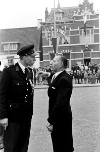 Een politieagent in discussie met een aanwezige, Bestanddeelnr 916-4838