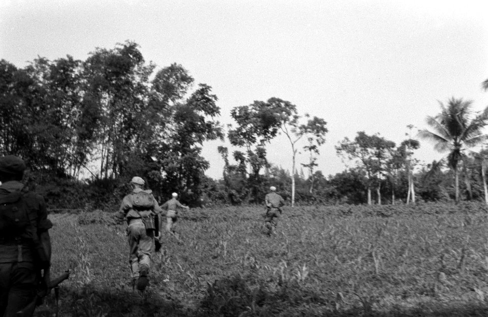 Een militaire eenheid of patrouille rent over een open veld, Bestanddeelnr 2829