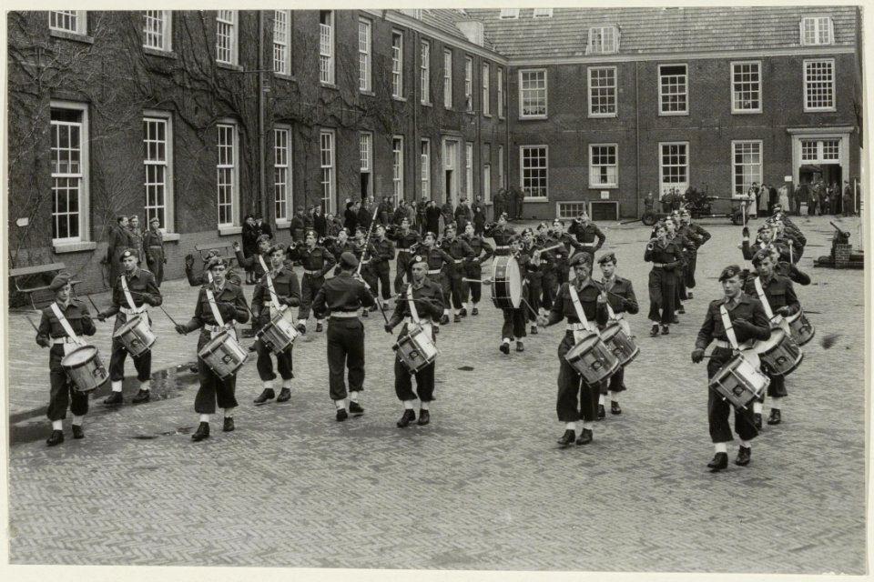 Een militaire drumband tijdens een repetitie op de binnenplaats van de infanteriekazerne. NL-HlmNHA 54004600