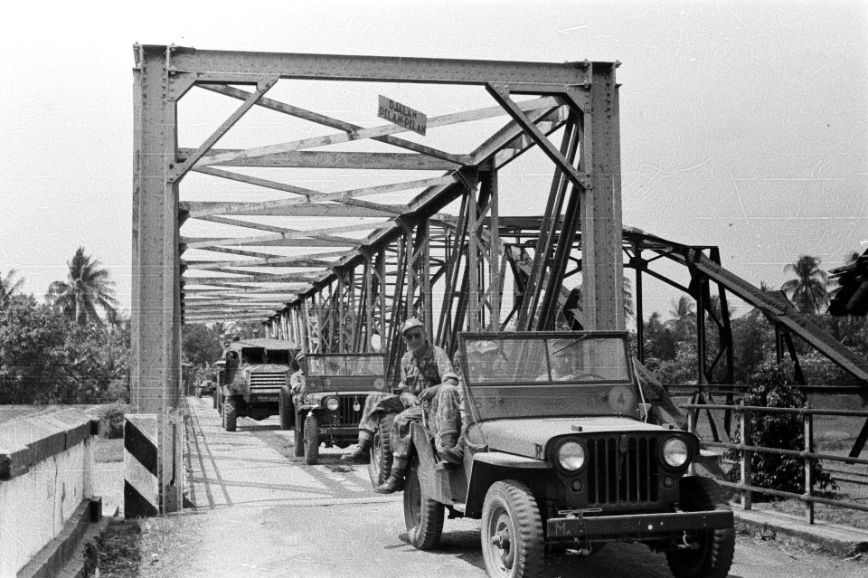 Een militaire colonne passeert een Baileybrug. Aan de brug hangt een bordje met , Bestanddeelnr 1757