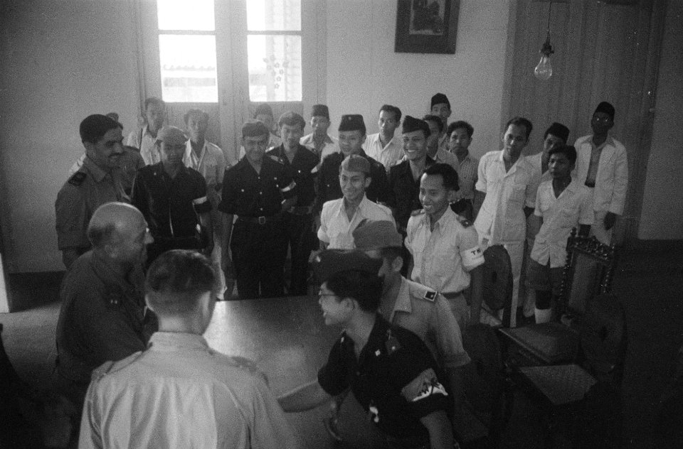 Een Nederlandse en Indonesische officier schudden elkaar de hand terwijl een gro, Bestanddeelnr 799