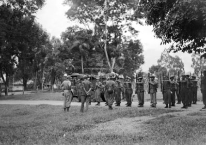 Een peloton KNIL-militairen staat aangetreden voor een kazerne. Acher hen een v, Bestanddeelnr 15924