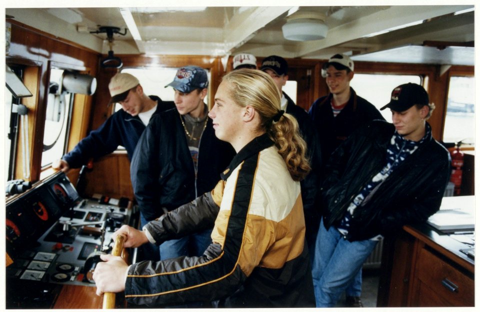 Een leerlinge van de opleiding Rijn- en binnenvaart van het Maritiem Instituut in IJmuiden aan het roer van het opleidingsschip Christina. NL-HlmNHA 54050185