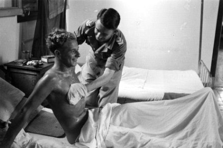 Een patient wordt gewassen in zijn hospitaalbed, Bestanddeelnr 5655