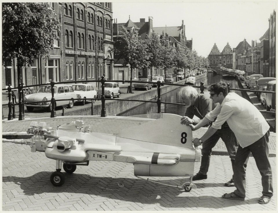Een plastiek van de Japanse kunstenaar Tajiri op weg naar Galerie T, met links het gebouw van Drukkerij Planeta. NL-HlmNHA 54011856