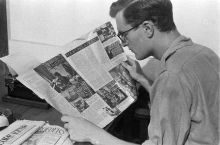 Een redacteur leest een exemplaar van het tijdschrift Wapenbroeders, gezeten aa…, Bestanddeelnr 380-5-6