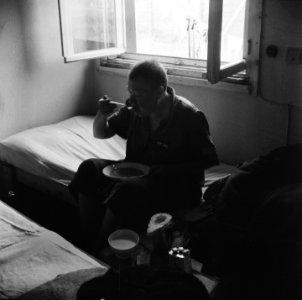 Een repatriant eet een bord soep, gezeten op bed, Bestanddeelnr 900-5089