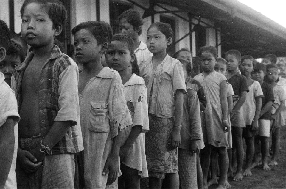 Een rij kinderen in kapotte kleren kledinguitdeling, Bestanddeelnr 430