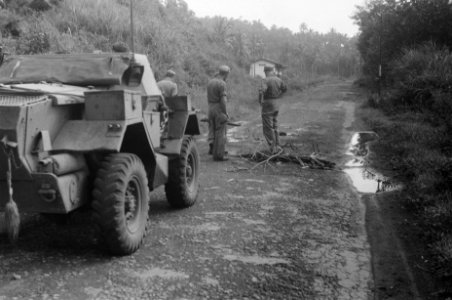 Een scoutcar staat stil op een weg Voor het voertuig inspecteren enkele militai, Bestanddeelnr 481-4-1