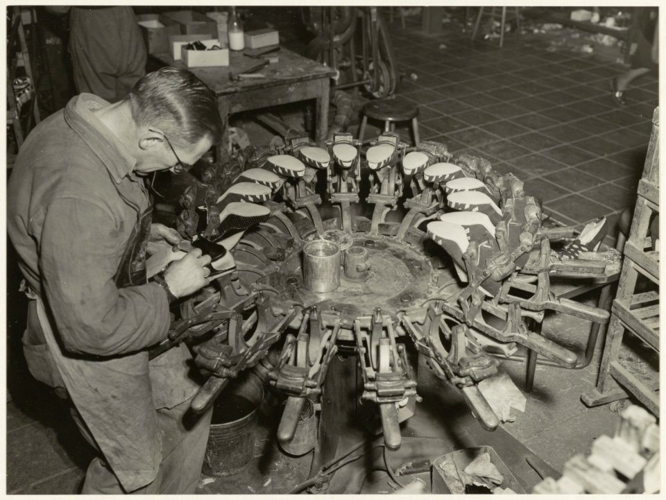 Een schoenmaker aan het werk bij Fort Schoenenindustrie aan de Bloemhofstraat 14, NL-HlmNHA 54010562