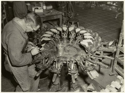 Een schoenmaker aan het werk bij Fort Schoenenindustrie aan de Bloemhofstraat 14, NL-HlmNHA 54010562
