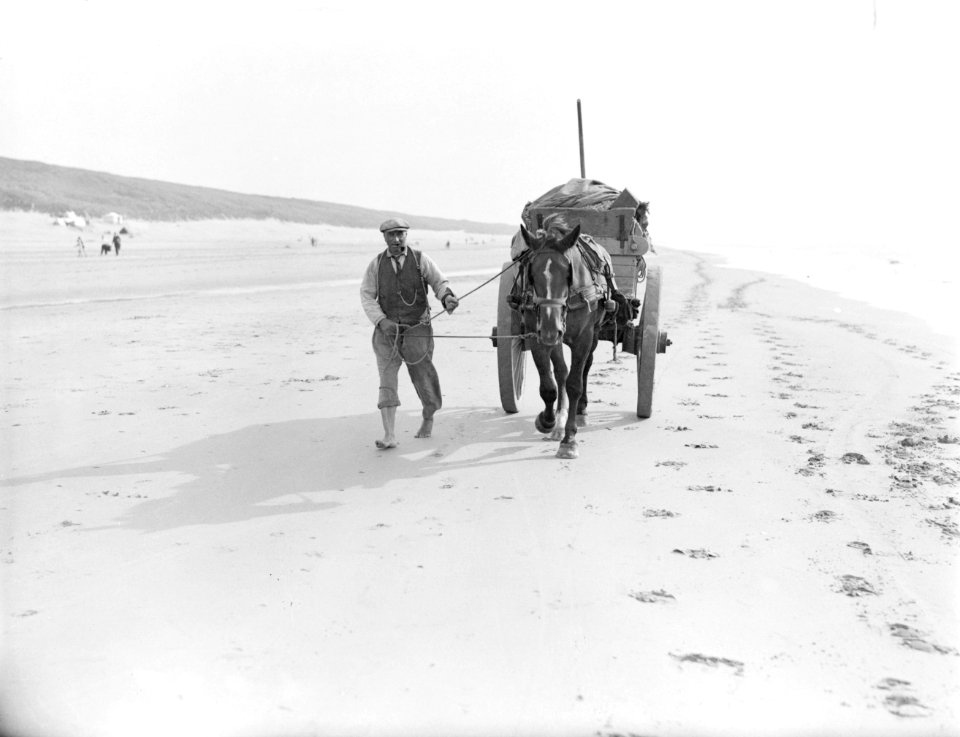 Een schelpenkar met een man er naast op het strand van Zandvoort, Bestanddeelnr 252-0784