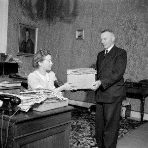 Een secretaresse overhandigt post aan een bode, Bestanddeelnr 255-7843
