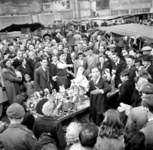 Een standwerker prijst zijn koopwaar aan, Bestanddeelnr 191-0931