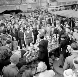 Een standwerker prijst zijn koopwaar aan, Bestanddeelnr 191-0929