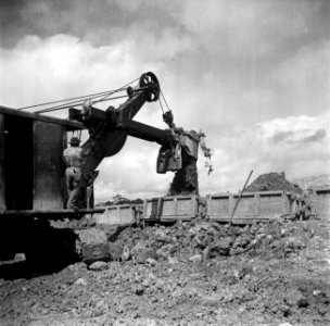 Een shovel laadt erts in een kipkar op het terrein van de Surinaamse Bauxiet Maa, Bestanddeelnr 252-6614