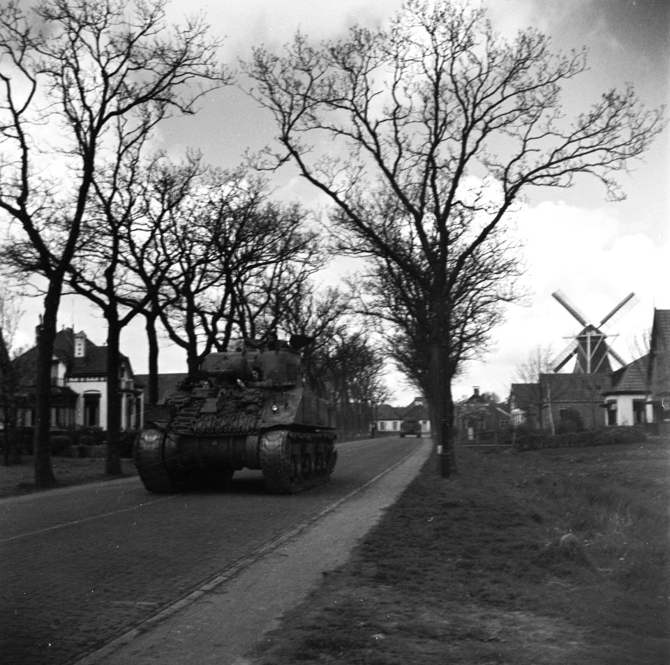 Een Sherman tank rijdt over een weg Rechts een molen, Bestanddeelnr 900-3011
