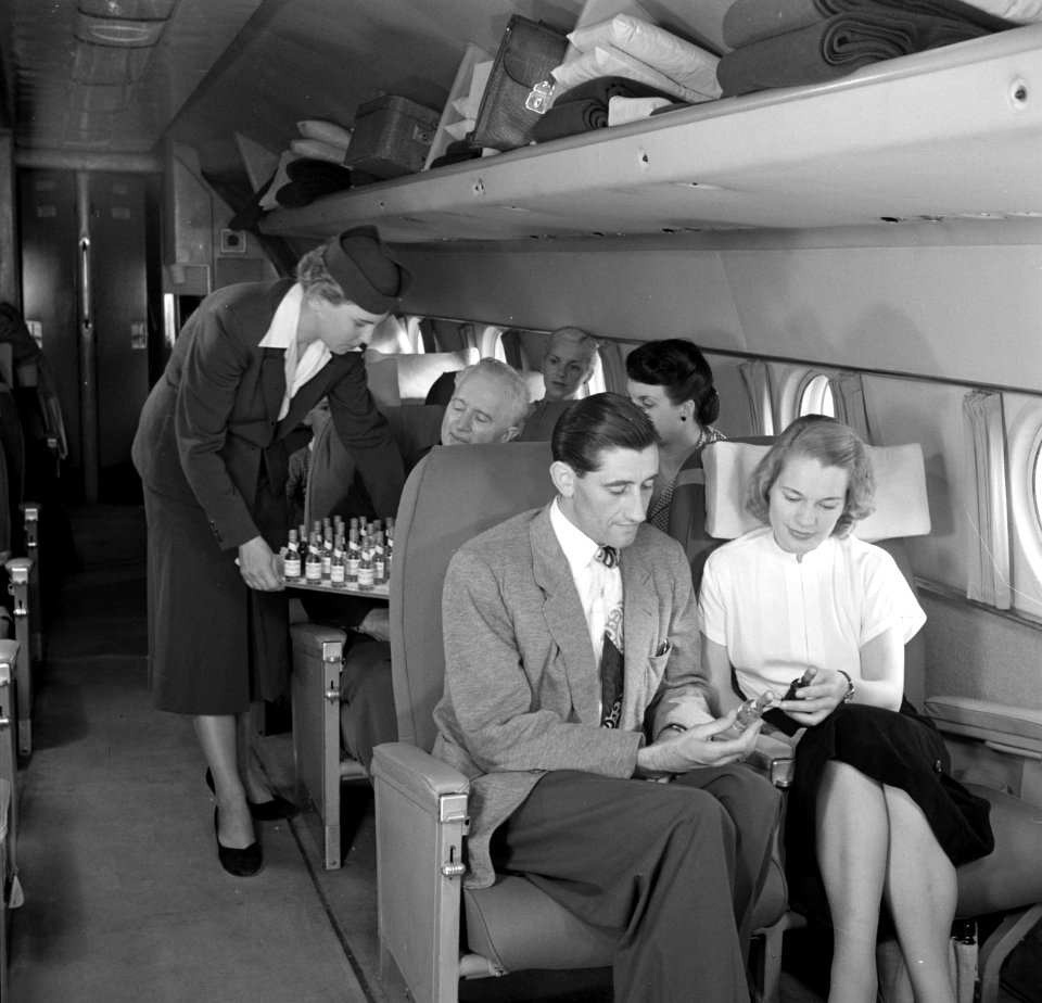 Een stewardess deelt flesjes drank uit, Bestanddeelnr 252-2069