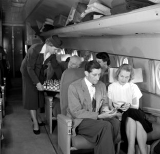 Een stewardess deelt flesjes drank uit, Bestanddeelnr 252-2069