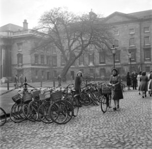 Een studente zoekt haar fiets die gestald is op de binnenplaats van het Trinity , Bestanddeelnr 191-0859