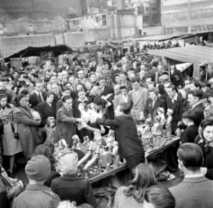 Een standwerker prijst zijn koopwaar aan, Bestanddeelnr 191-0932