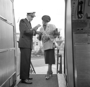 Een steward en een vrouwelijke passagier bij de ingang van een KLM-vliegtuig, Bestanddeelnr 254-5443