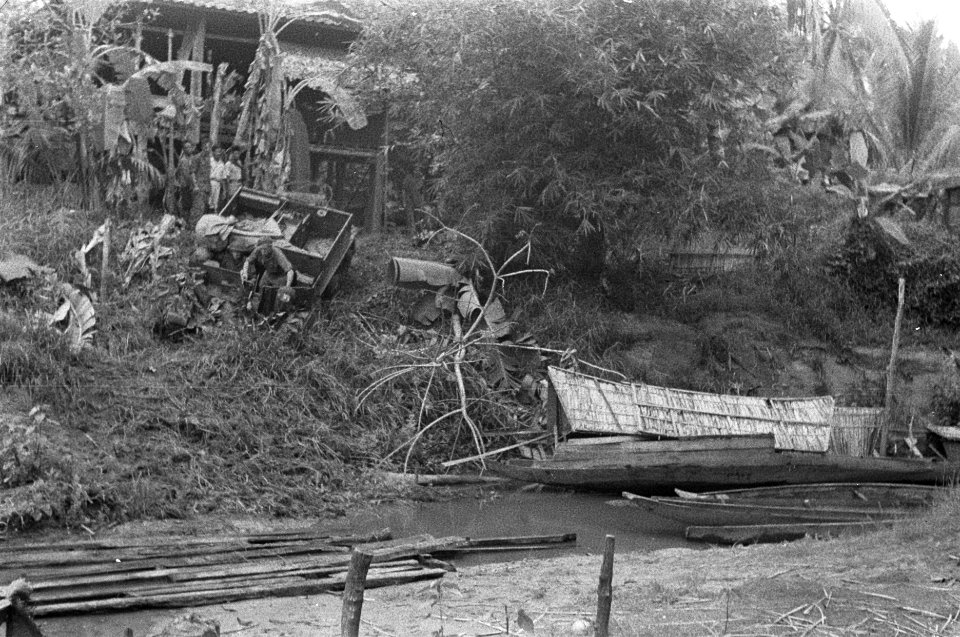 Een Universal Carrier rijdt een steil talud af. In de rivier liggen planken en p, Bestanddeelnr 348-4-1