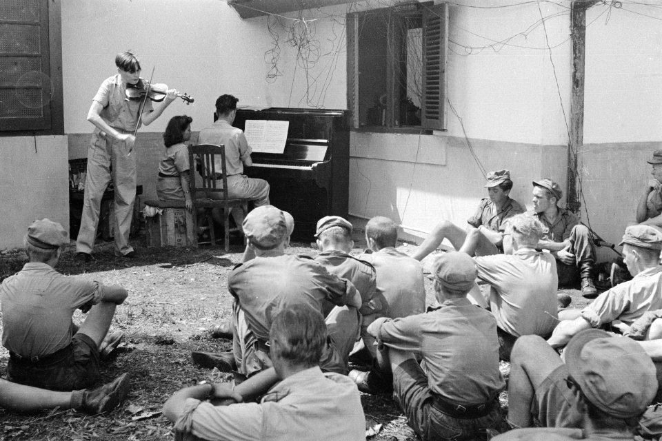 Een violist speelt, begeleidt door een pianist Soldaten luisteren zittend, Bestanddeelnr 269-4-4