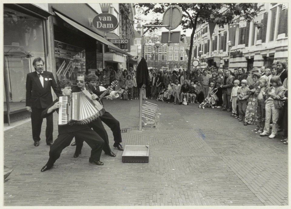 Een Utrechtse muziekgroep trekt veel belangstelling in de Grote Houtstraat gezien naar de Grote Markt. NL-HlmNHA 54011459