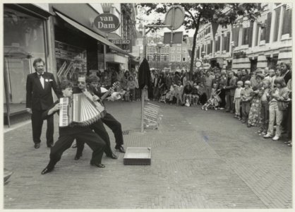 Een Utrechtse muziekgroep trekt veel belangstelling in de Grote Houtstraat gezien naar de Grote Markt. NL-HlmNHA 54011459