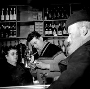 Een van de mannen staat aan de bar terwijl de barkeeper en barkeepster een blikj, Bestanddeelnr 252-9498