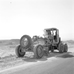 Een tractor verplaatst zand voor de aanleg van een weg, Bestanddeelnr 255-2706