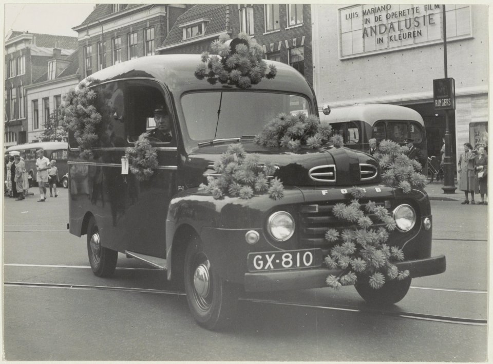 Een ter gelegenheid van het bloemencorso versierde auto op het Houtplein voor de Lido bioscoop. NL-HlmNHA 54010470