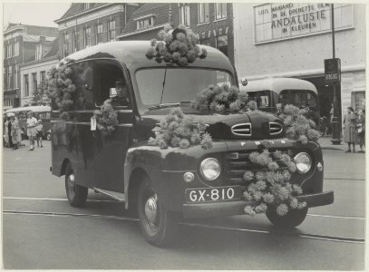 Een ter gelegenheid van het bloemencorso versierde auto op het Houtplein voor de Lido bioscoop. NL-HlmNHA 54010470