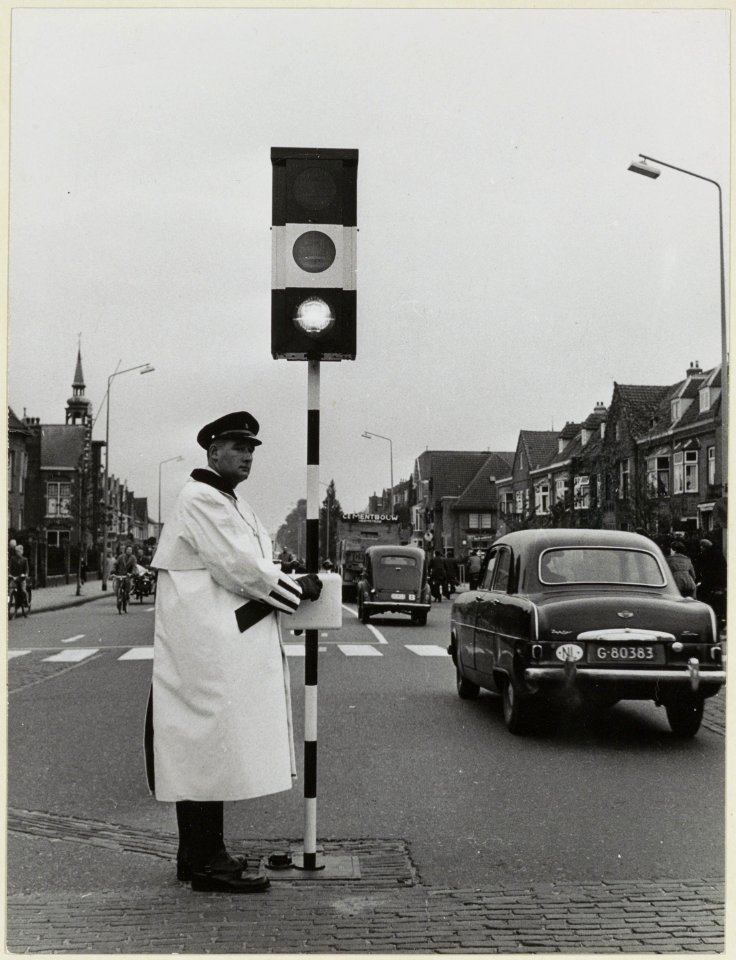 Een verkeersagent met een verplaatsbaar verkeersbord op de viersprong Zaanenlaan - Rijksstraatweg - Zaanenstraat. NL-HlmNHA 54004160