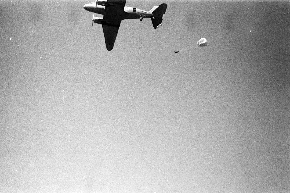 Een vliegtuig werpt voorraden per parachute af, Bestanddeelnr 280-5-5