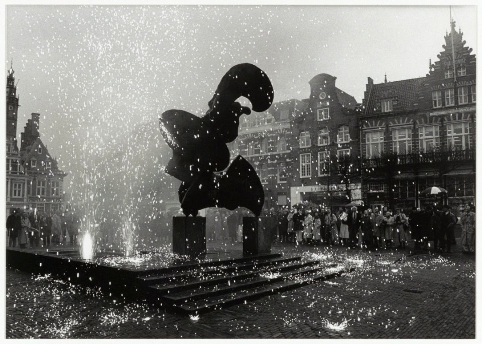 Een vonkenregen daalt neer op de zonnevechter bij de feestelijke ingebruikstelling van de fontein naast het beeld. NL-HlmNHA 54033982