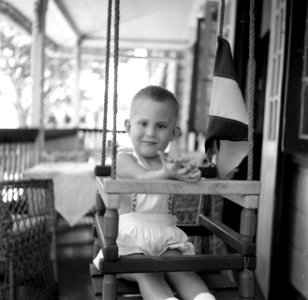 Een zoontje van de familie Crena Uiterwijk in een schommel in Suriname, Bestanddeelnr 252-6887