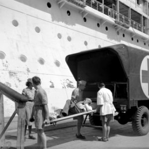 Een zieke wordt aan boord van het MS Oranje gedragen, Bestanddeelnr 255-8314