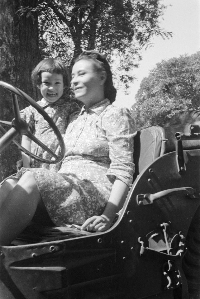 Een vrouw en een meisje poseren in een jeep, Bestanddeelnr 8-4-4