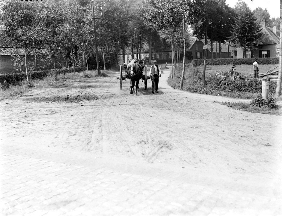 Een man loopt met paard en wagen over een onverharde weg in Best, Bestanddeelnr 252-0737