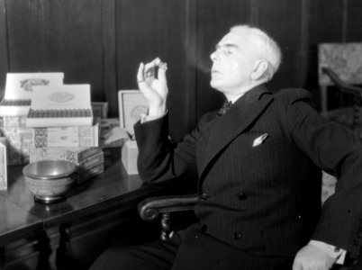 Een man rookt een sigaar in de zaak van Hajenius, Bestanddeelnr 252-1316